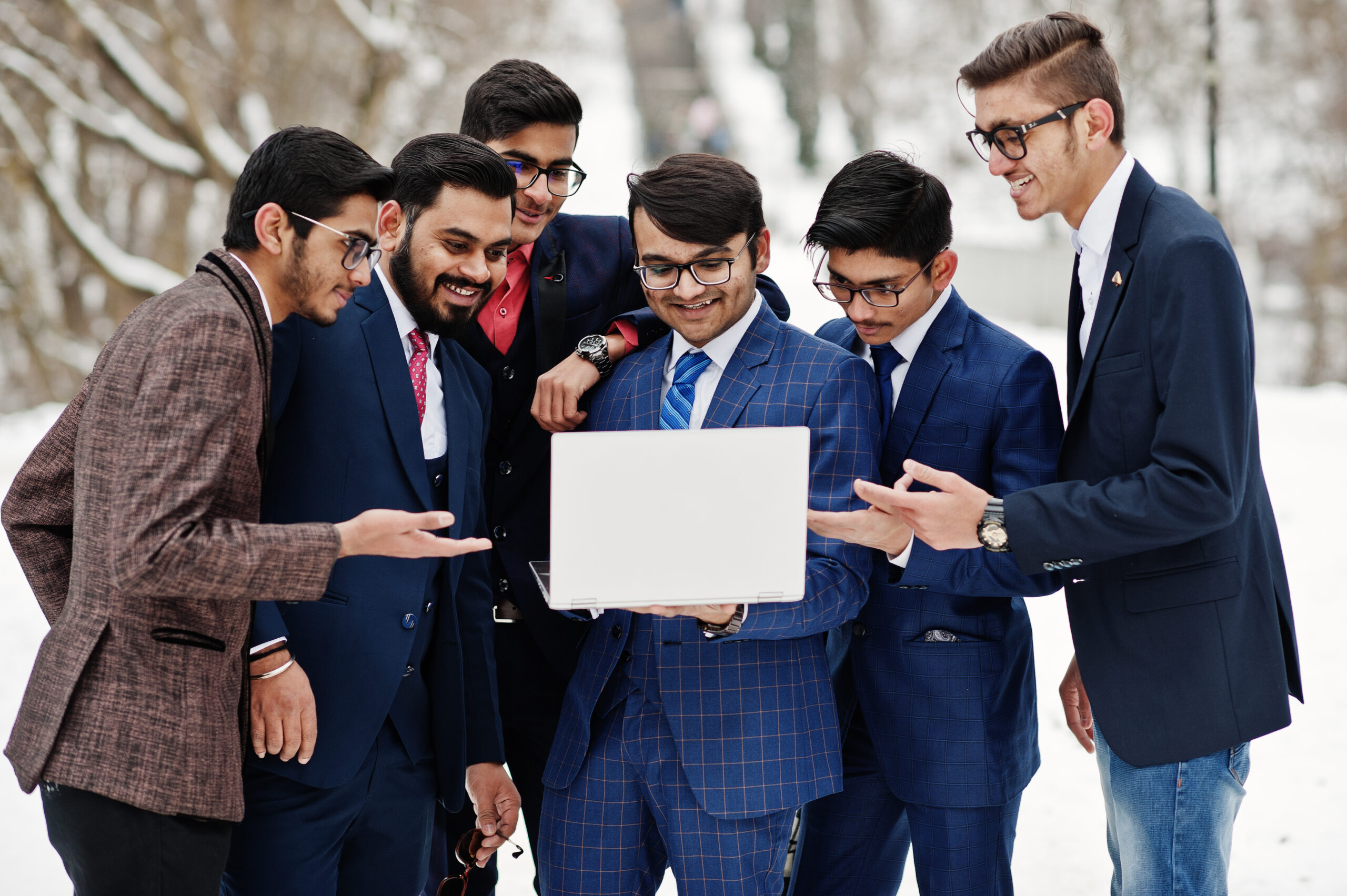 Group of six indian businessman in suits posed outdoor in winter